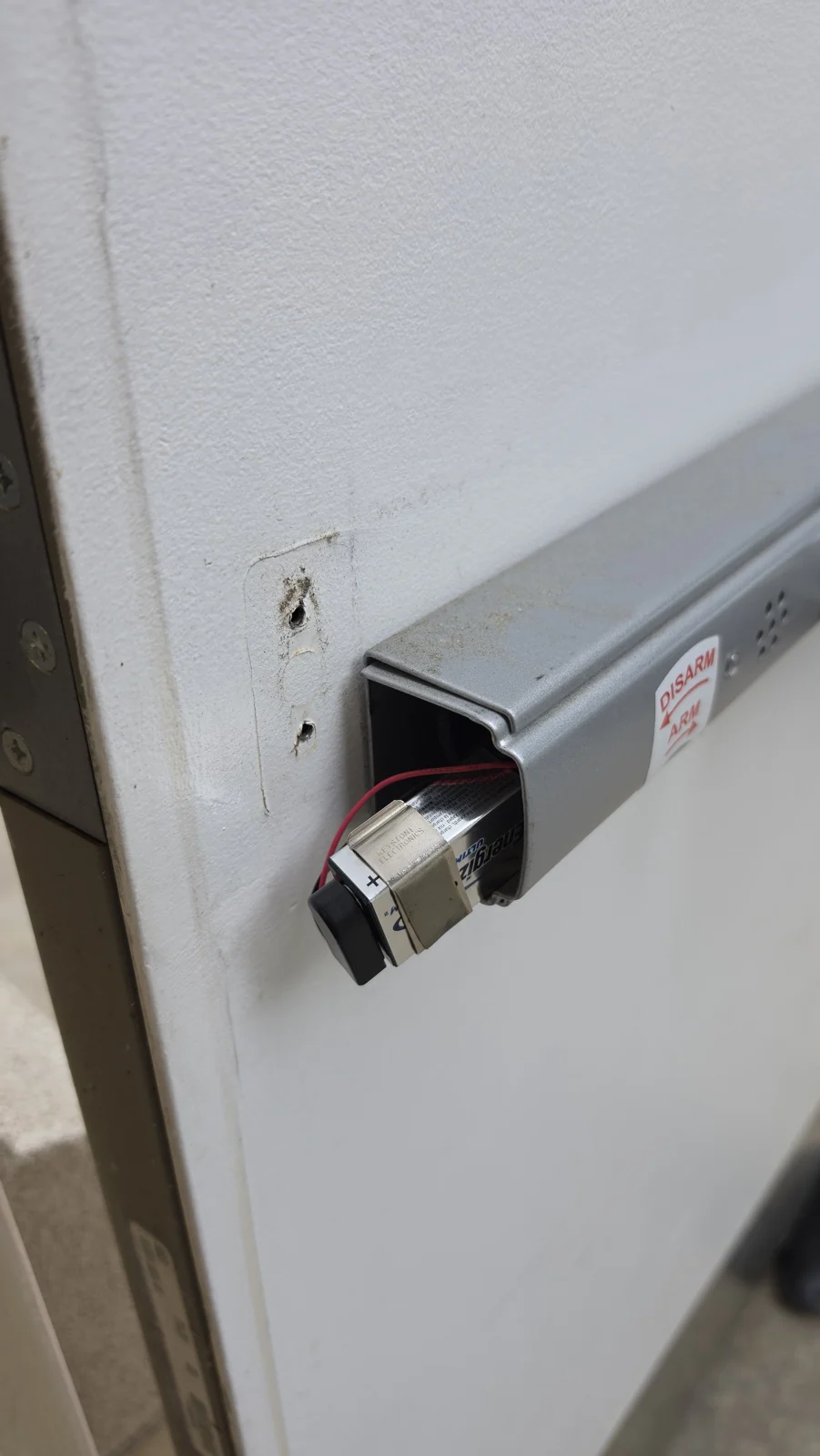 Alarm battery connection during panic bar servicing.
